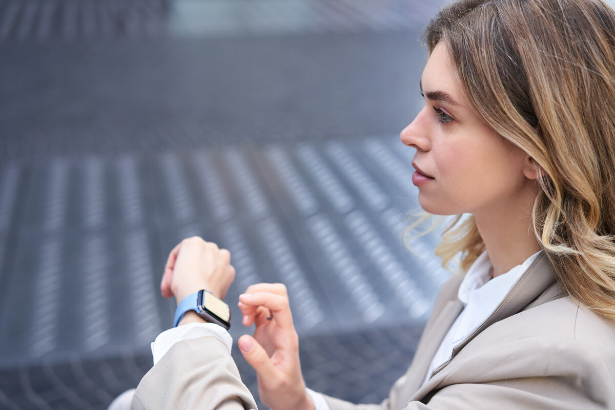 blonde woman looking at her watch