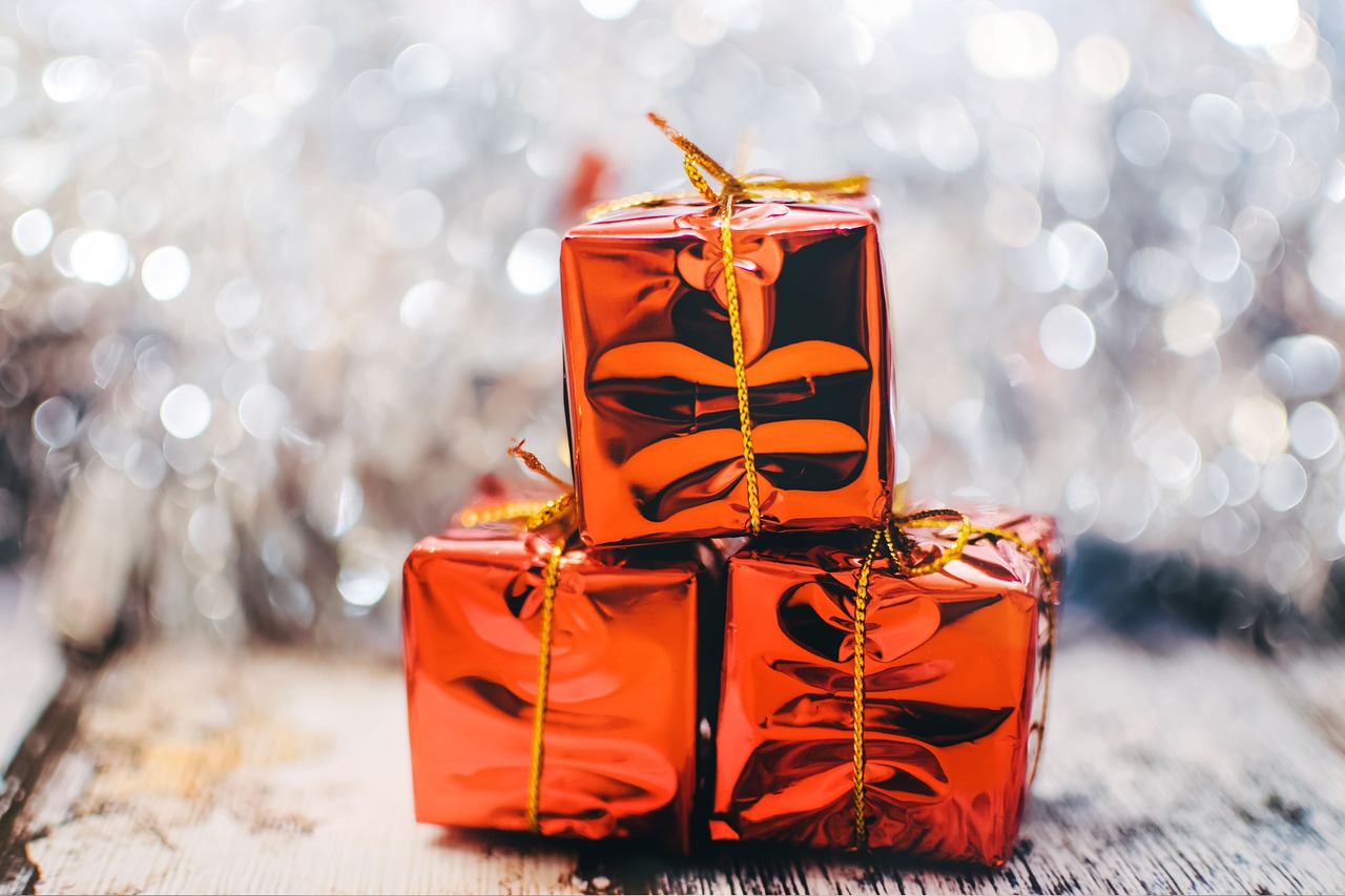 three golden wrapped gifts on top of each other