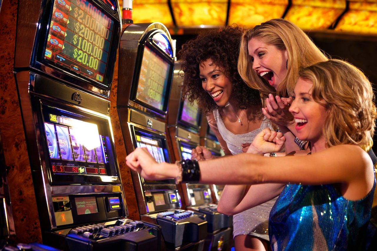 women playing slots in a casino